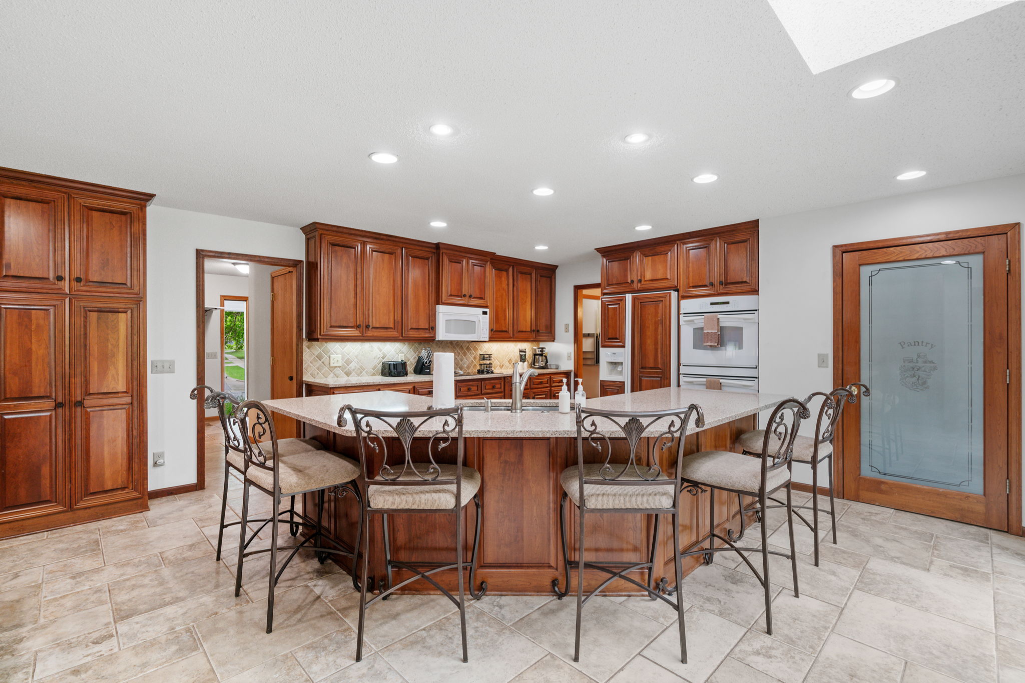 Elegant kitchen with rich wooden cabinetry and granite island.