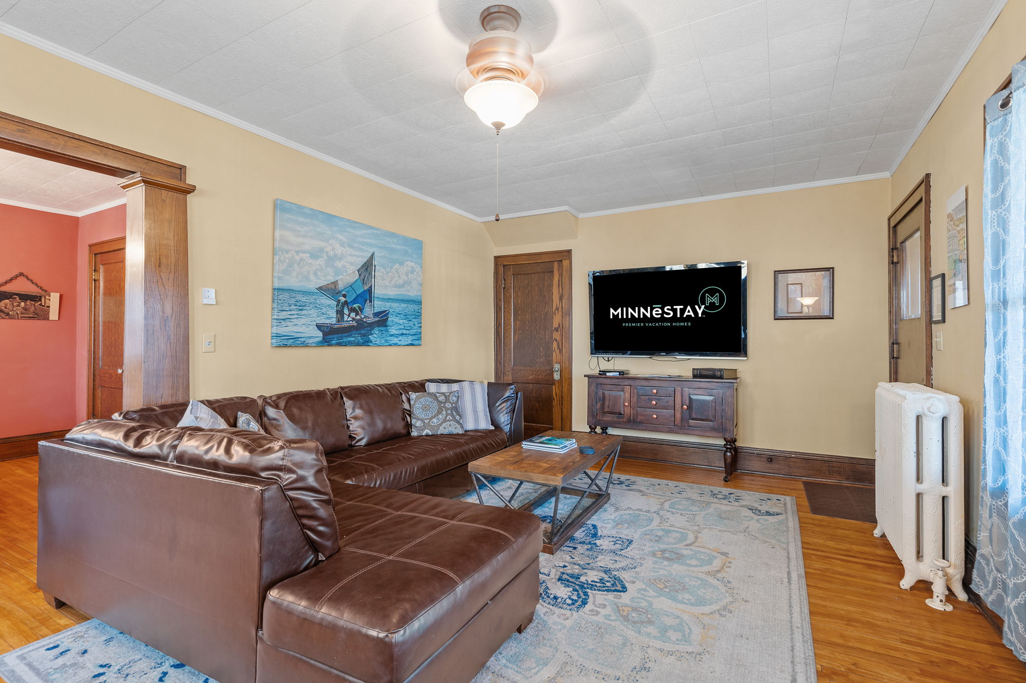 Cozy living room with leather sofa and serene seascape painting.