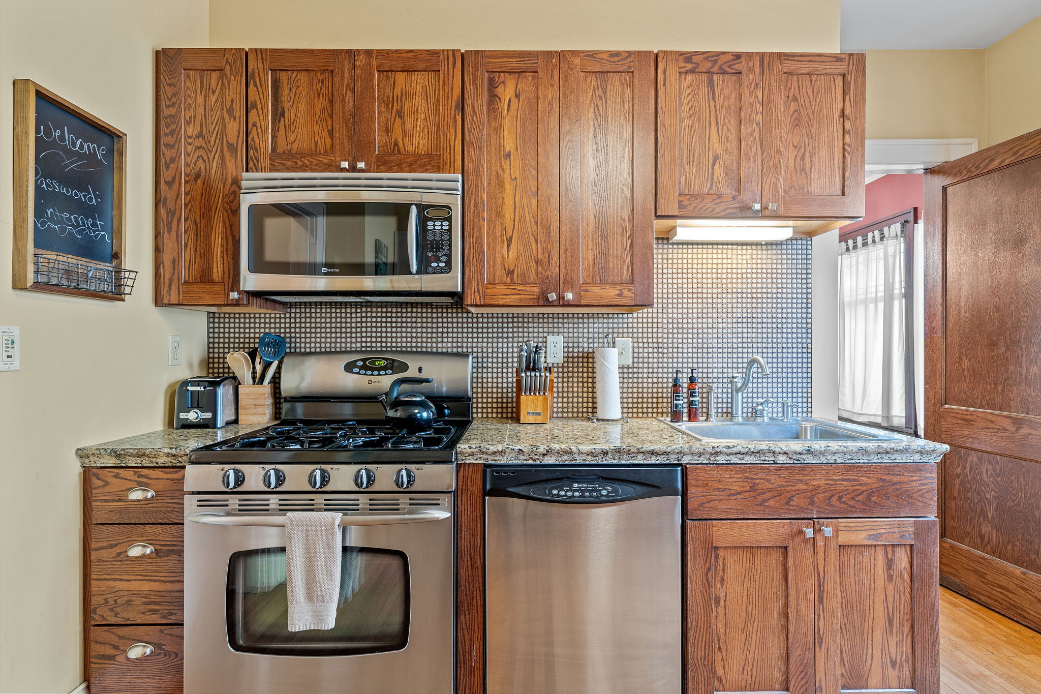 A cozy kitchen with modern appliances and warm wooden cabinetry.