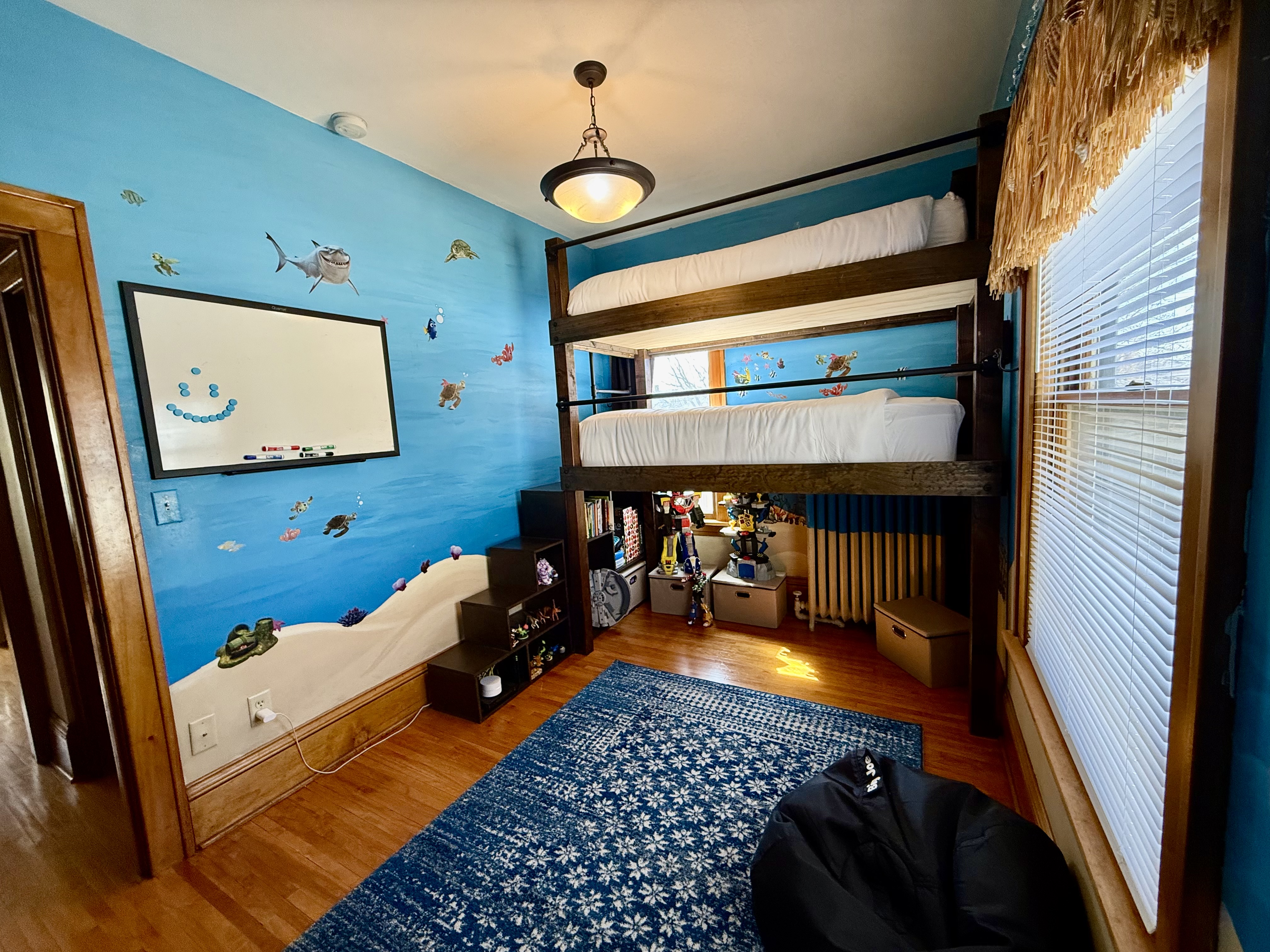 A vibrant ocean-themed children's bedroom with a cozy bunk bed and playful decor.