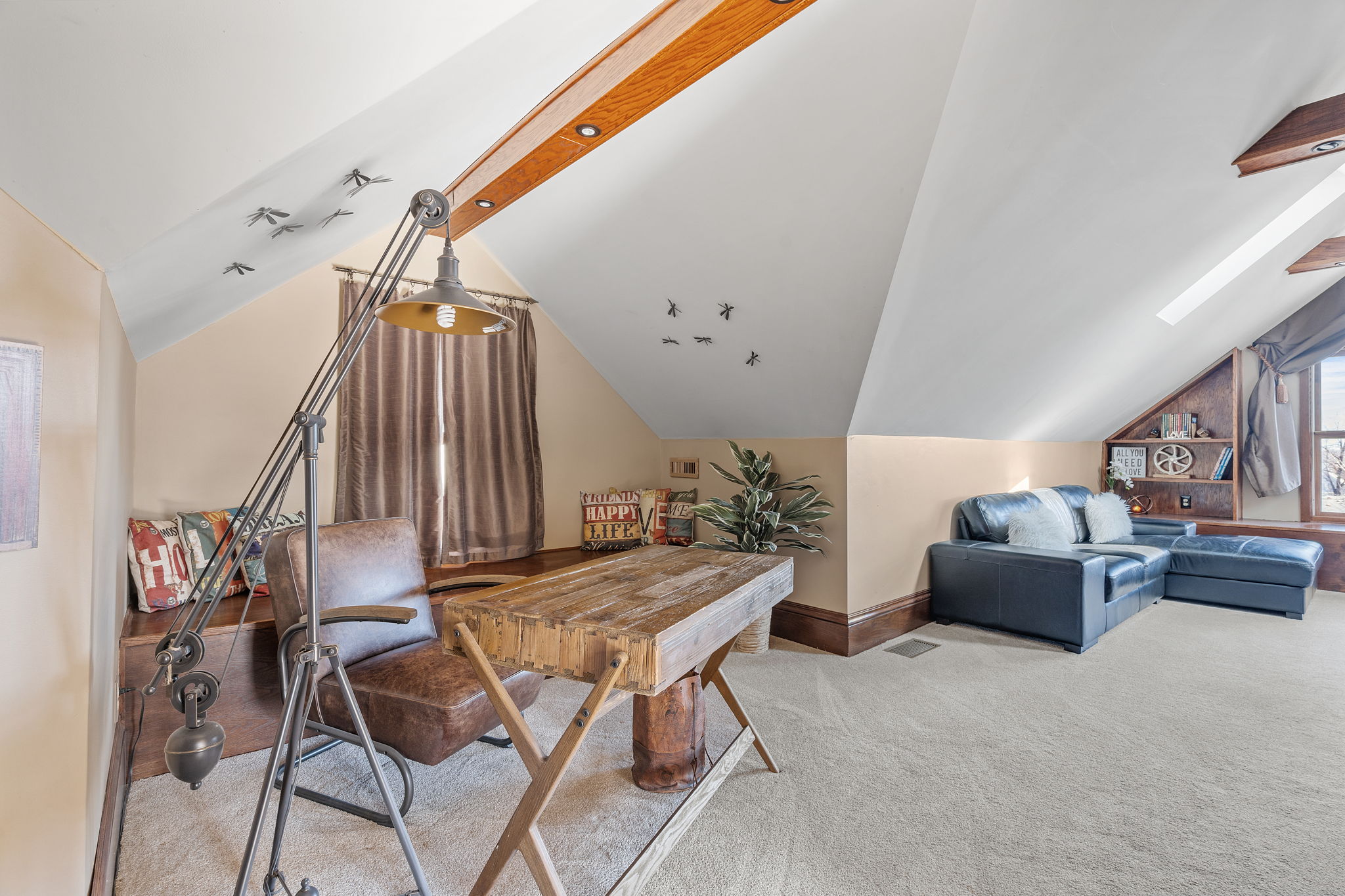 A stylish attic workspace combined with a cozy seating area.