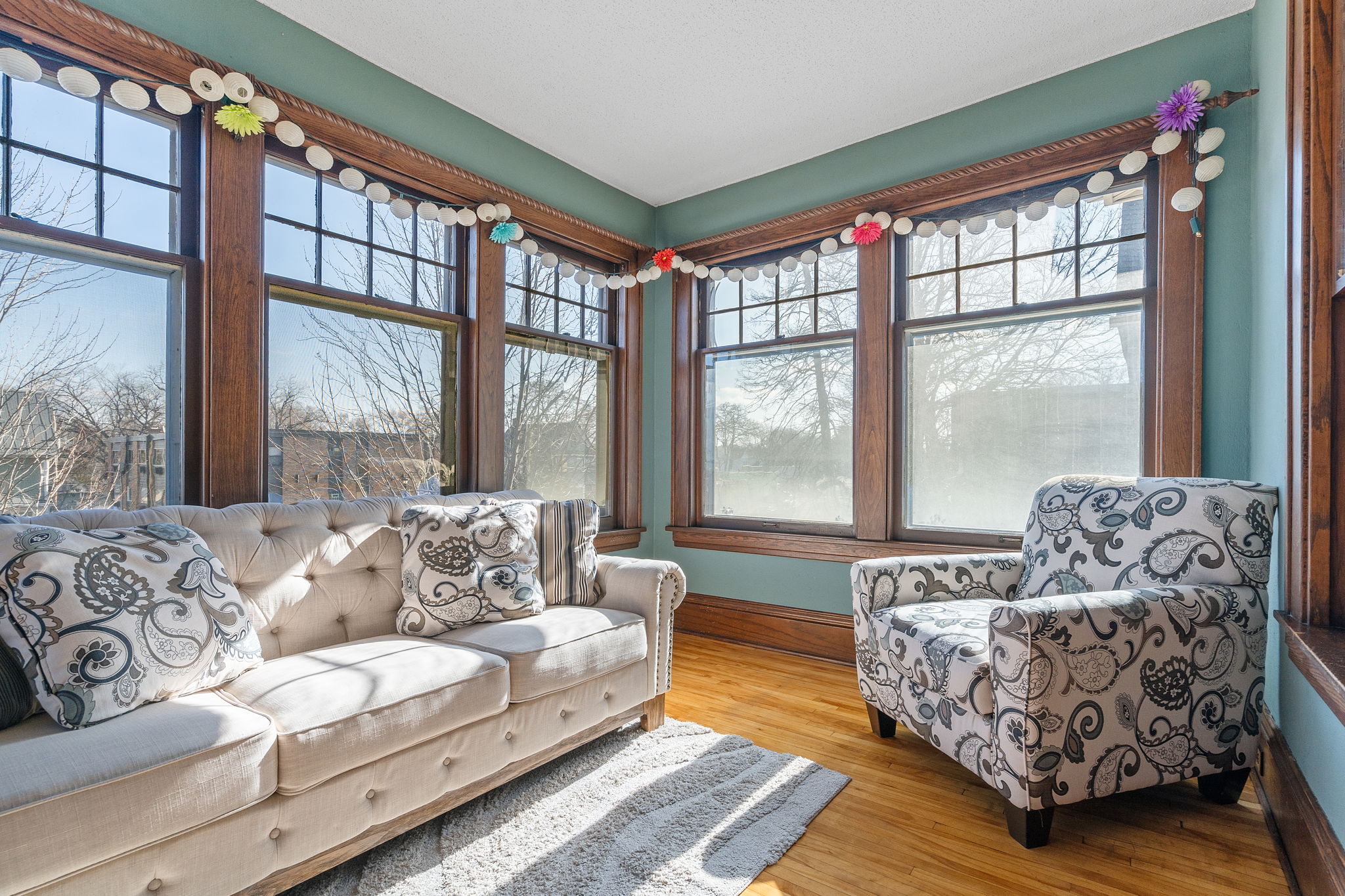 A bright and inviting sunroom with cozy furniture and decorative accents.