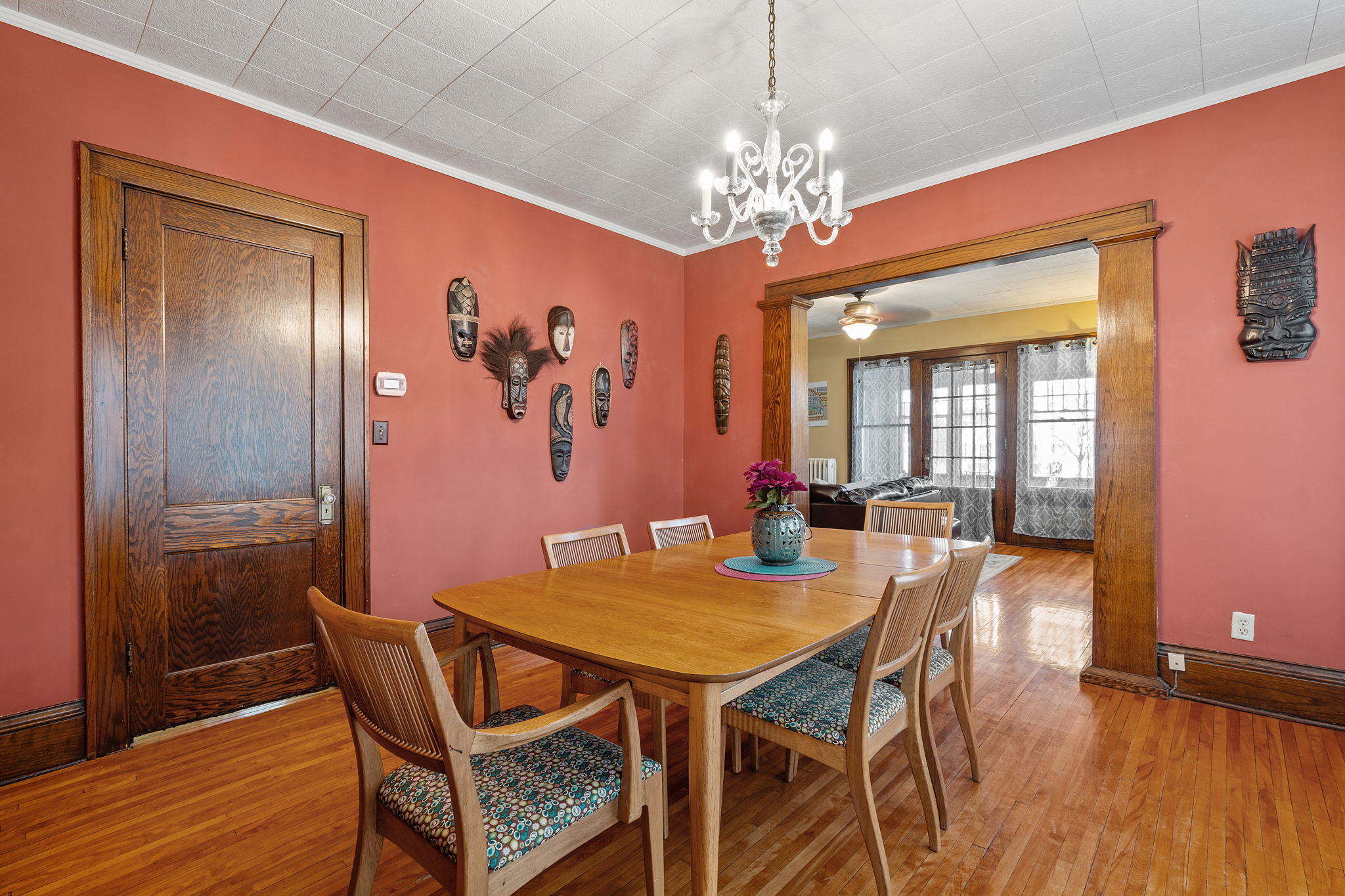 A warm and inviting dining room featuring a wooden table and tribal art.