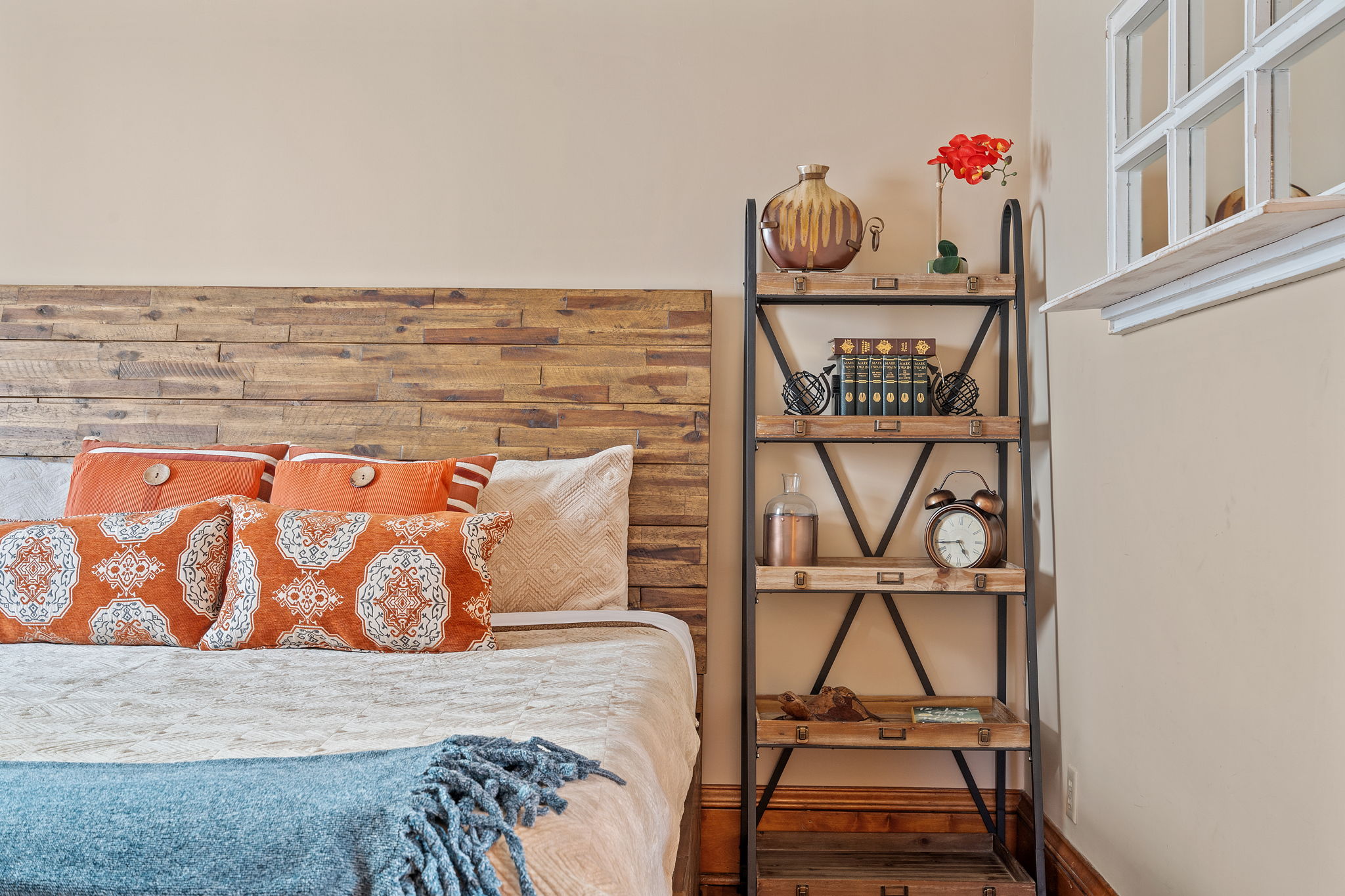 A cozy bedroom with rustic elements and colorful decor.