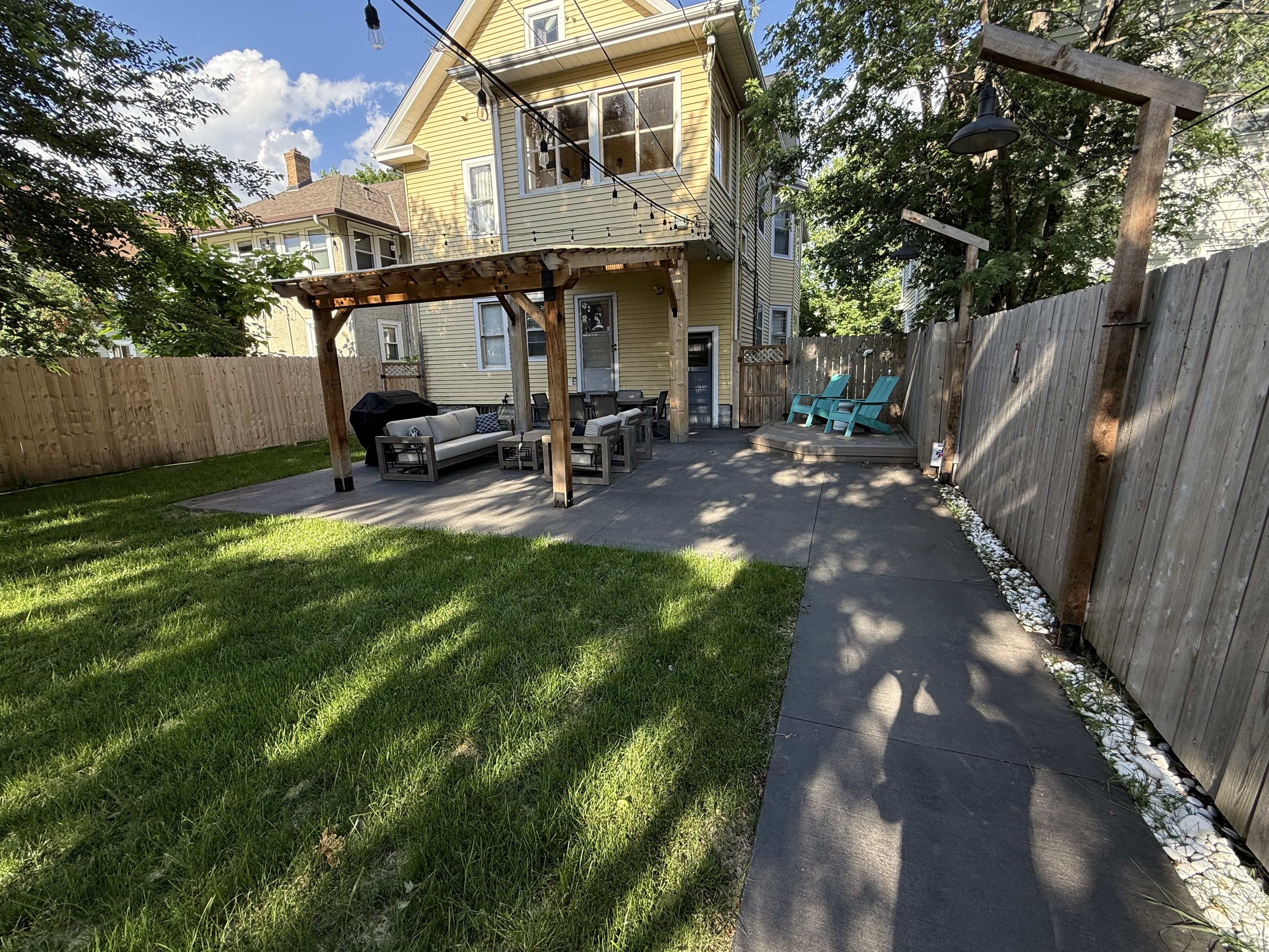 A charming backyard patio with comfortable seating and vibrant greenery.