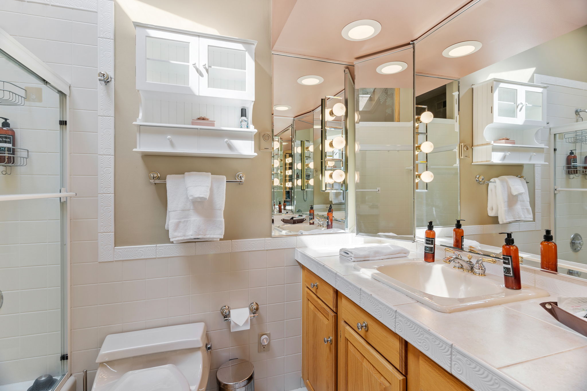 A bright and elegant bathroom featuring practical amenities and warm tones.