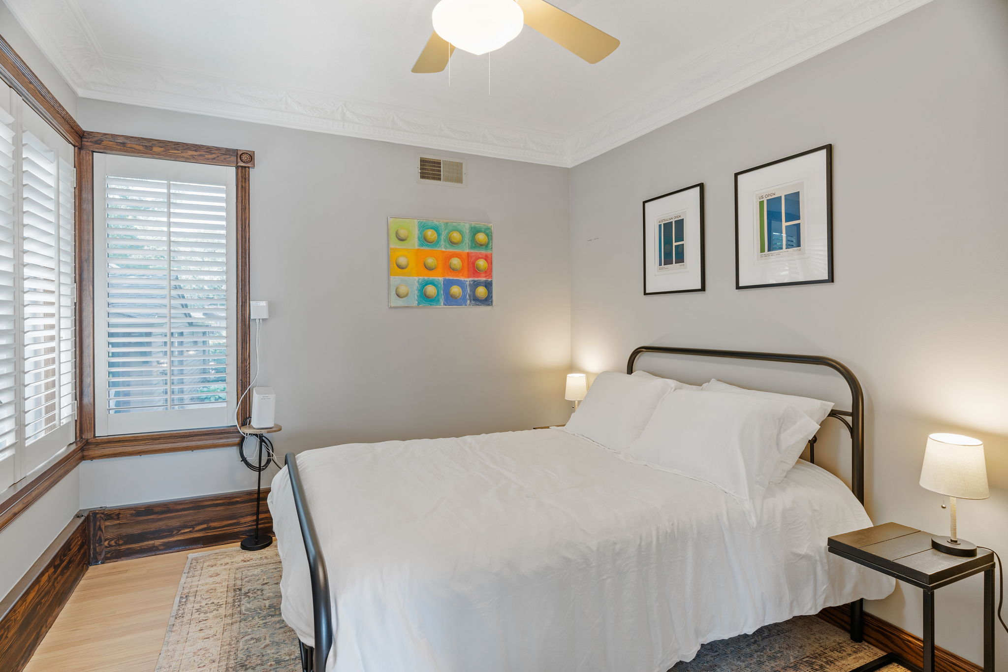 A cozy and stylish bedroom featuring a modern bed and colorful artwork.