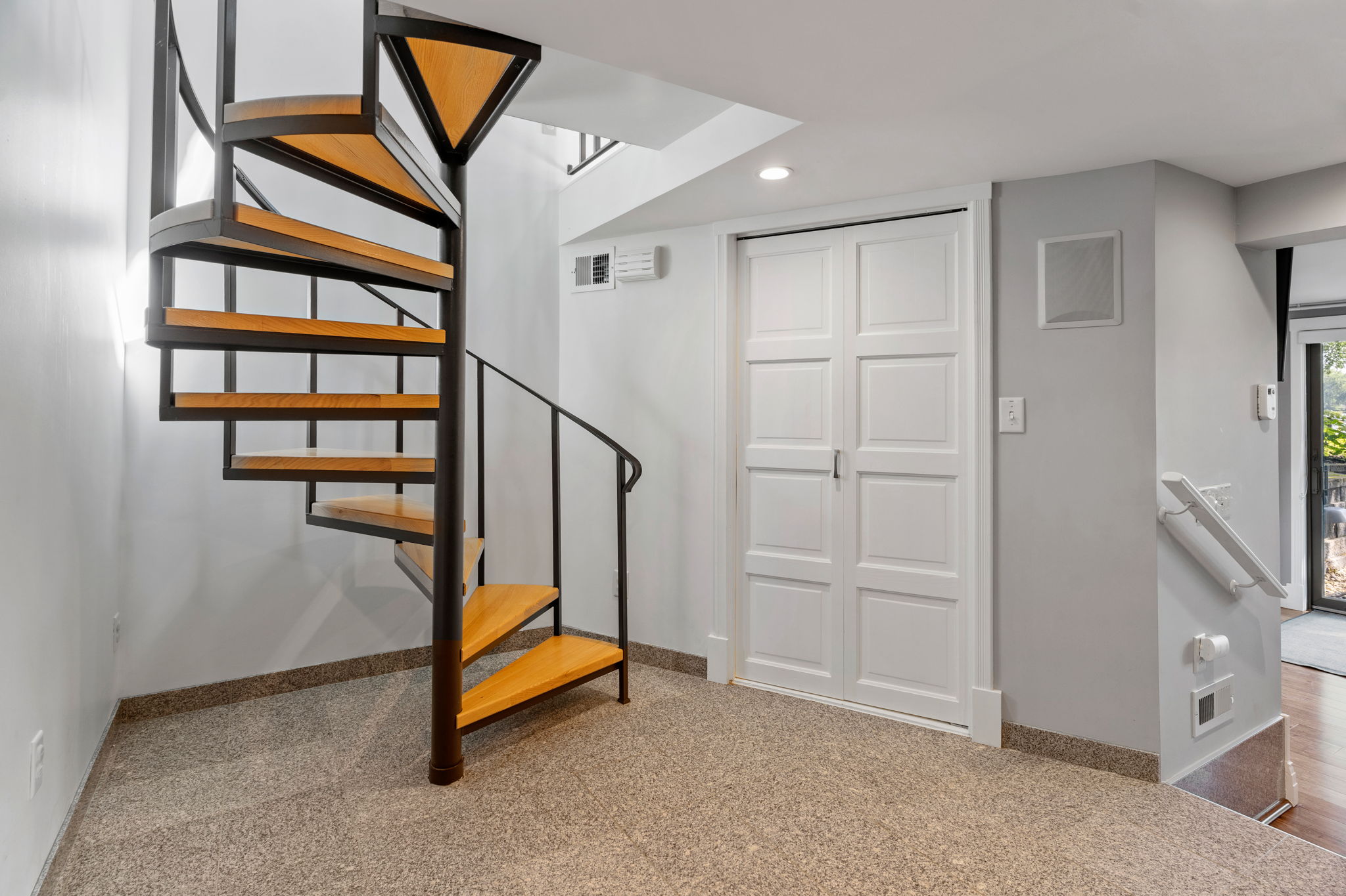 Elegant spiral staircase leading to an upper level in a modern home.