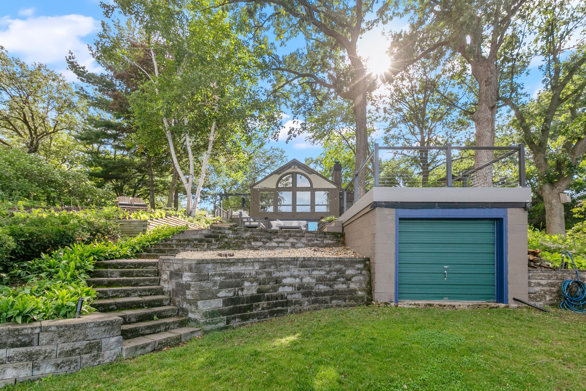 A beautiful backyard featuring a modern house and stone paths amidst lush greenery.