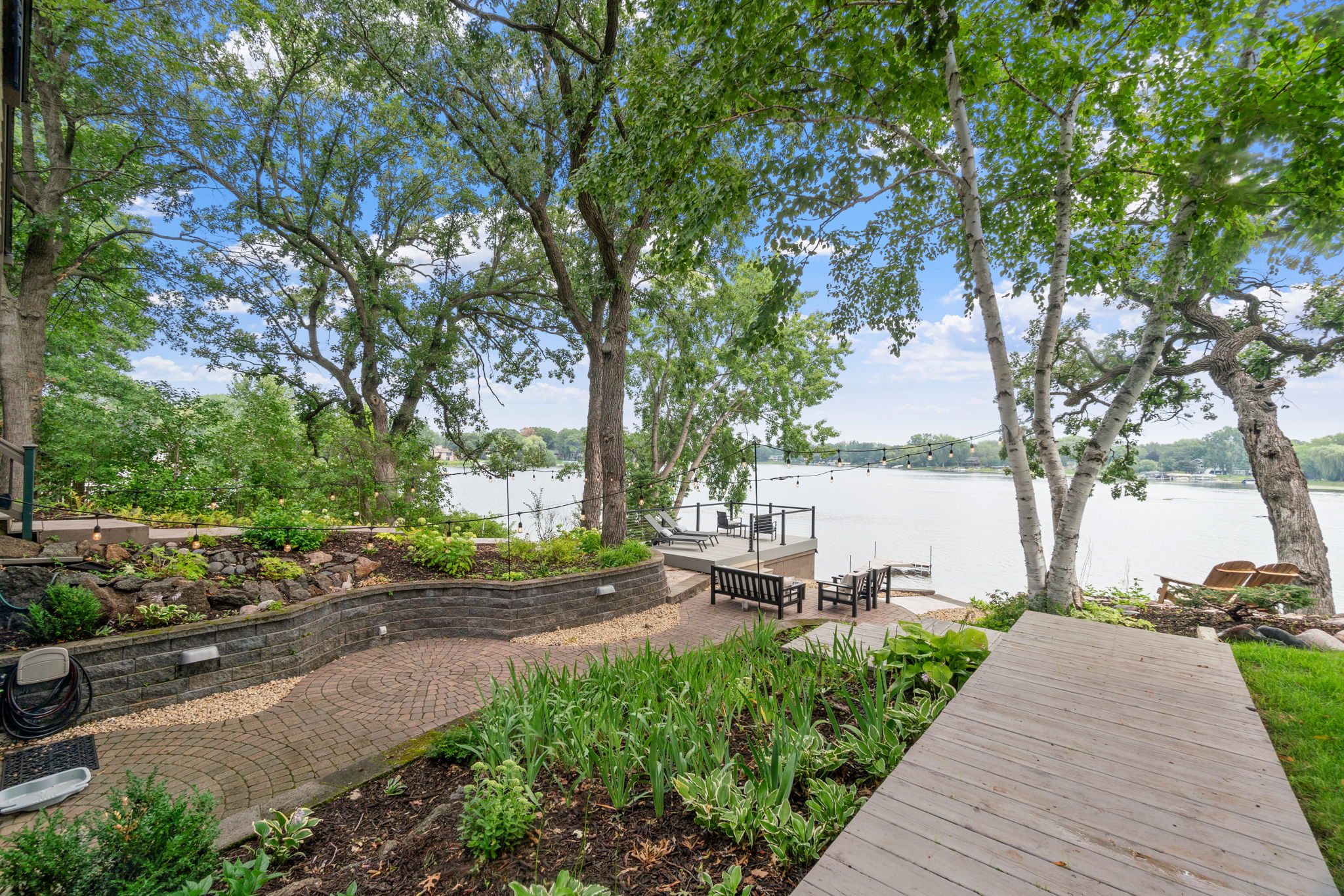 A tranquil lakeside retreat with lush greenery and comfortable seating.
