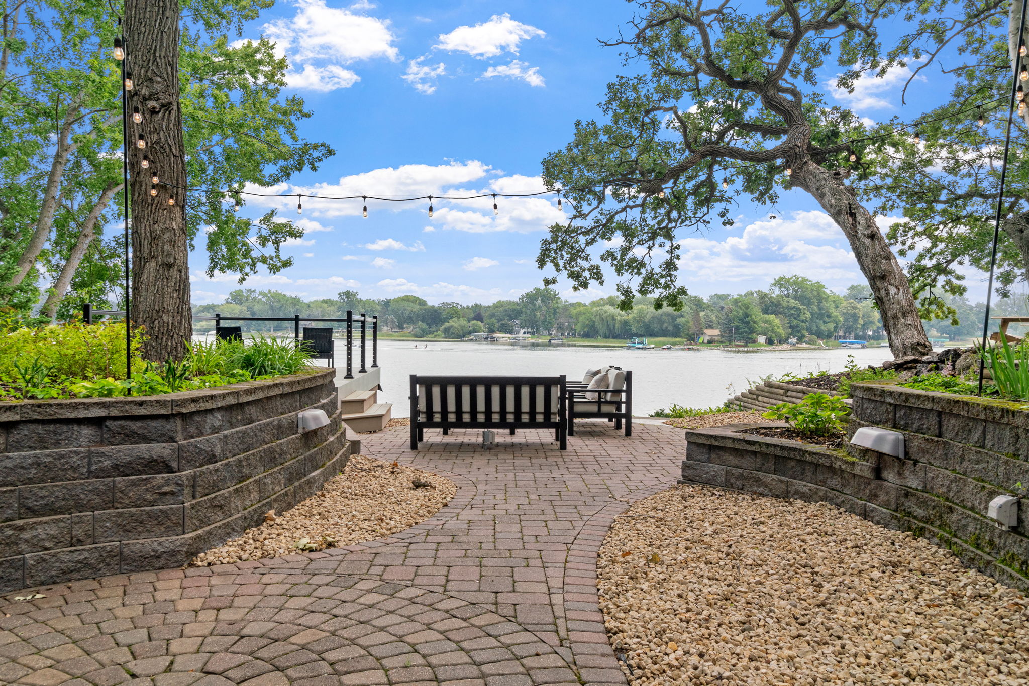 A cozy lakeside seating area with intertwined paths and lush greenery.