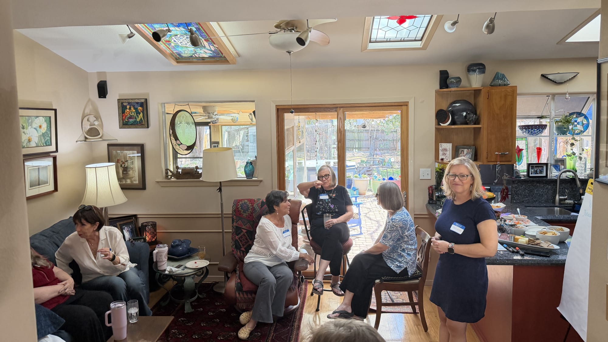 Women seated together in conversation at a Gathering For Good in a sunlit living room