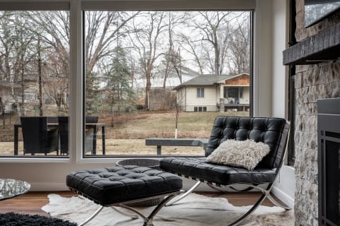 Modern living room featuring a black lounge chair and a view of the outdoors.