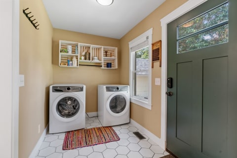 Interior view of a laundry room with washer, dryer, and natural lighting.