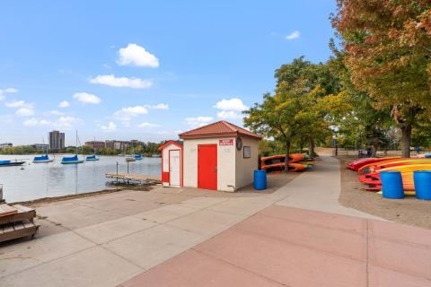 Lakeside view with a boat rental shack and kayaks lined up on the shore.