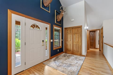 Welcoming foyer with blue walls, wooden details, and rustic mounted deer heads.
