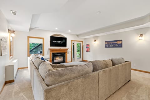 Cozy living room featuring a sectional sofa, mounted TV, and fireplace.