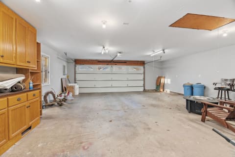 A spacious garage with wooden storage cabinets and an open workspace area.