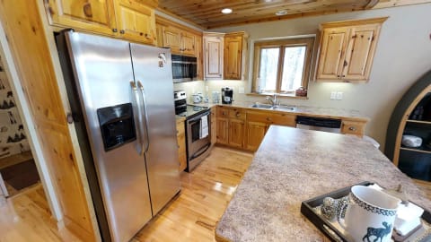 A cozy kitchen showcasing wood cabinetry, stainless steel appliances, and a decorative tray.