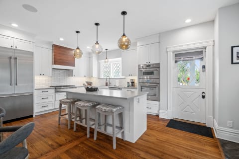Modern kitchen with a central island, stainless steel appliances, and pendant lights.