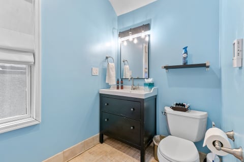 A stylish bathroom featuring bright blue walls and a modern vanity.