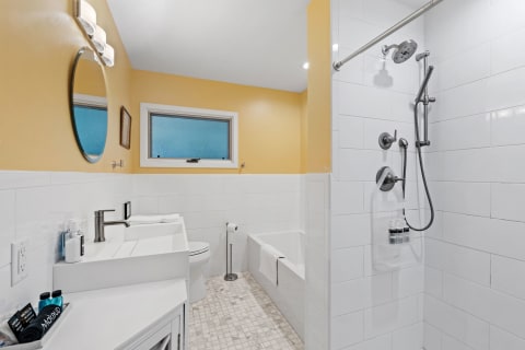 Contemporary bathroom featuring yellow walls, a white sink, and a bathtub.