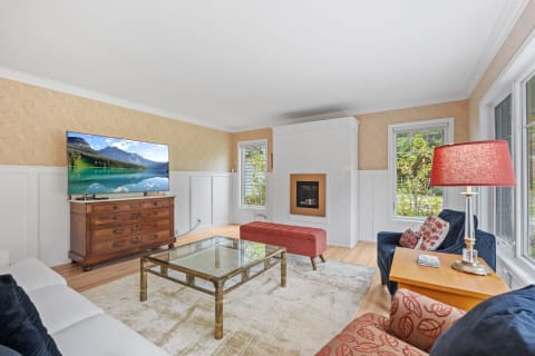Cozy living room with a TV, wooden furniture, and decorative lamp