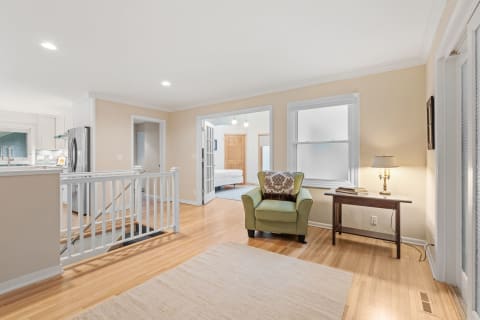 Interior view of a modern home with a green armchair and hardwood flooring.