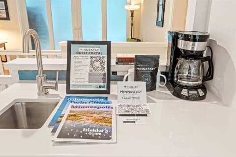 Kitchen countertop with a coffee maker, guest information brochures, and a gratitude card.
