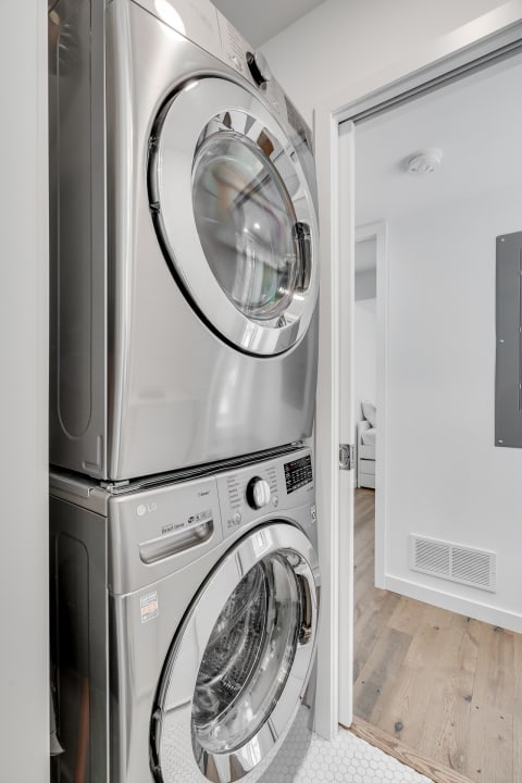 Sleek stainless steel washer and dryer in a contemporary laundry space.