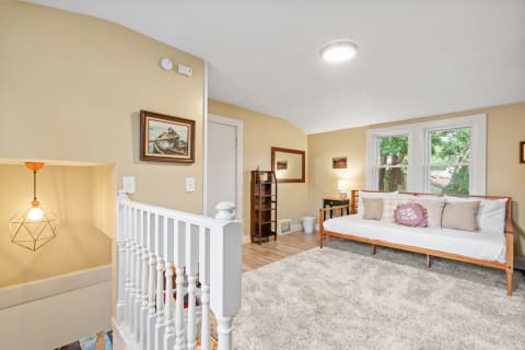 A comfortable room featuring a daybed, plush rug, and warm colors.