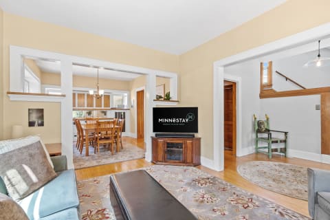 Cozy living room showcasing a sofa, TV, and dining area, filled with natural light.