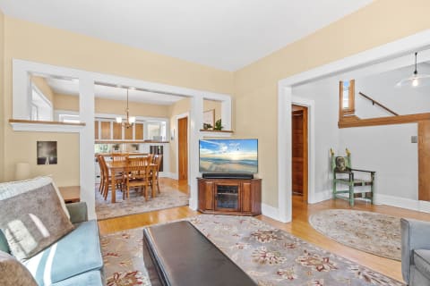 Interior view of a cozy living room connecting to a dining area with modern and rustic elements.