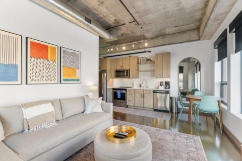 Stylish living room and kitchen with modern furnishings and artwork.