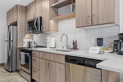 A sleek, modern kitchen with wood cabinets and stainless steel appliances.