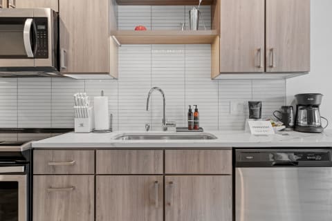 Modern kitchen with wood cabinets, stainless steel appliances, and a clean countertop.