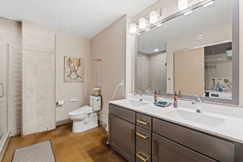 Contemporary bathroom with dual sinks, a walk-in shower, and an abstract art piece.