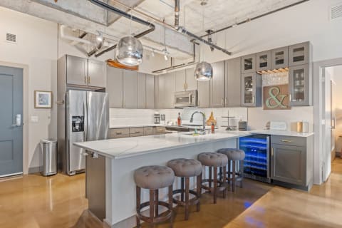 Modern kitchen design with gray cabinets and a white island countertop.