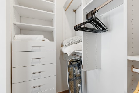 Interior view of a modern closet with drawers, shelving, and hangers.