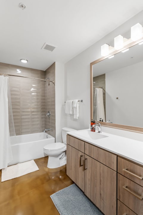 A spacious and modern bathroom with a bathtub, shower, and wooden vanity.