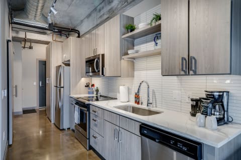 Modern kitchen with wooden cabinets, stainless steel appliances, and spacious countertops.