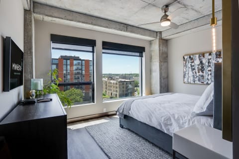 Minimalist bedroom with industrial elements and city views.