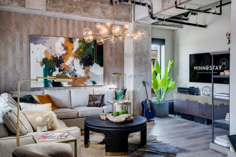 Modern living room featuring a gray sectional sofa, abstract art, and stylish decor.