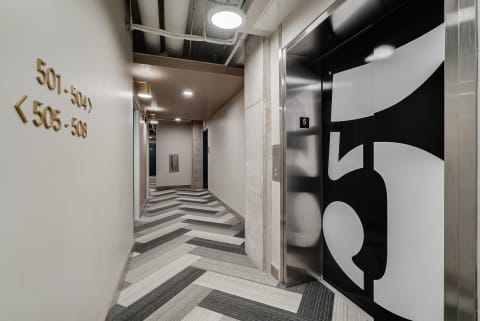 Interior corridor with modern elevator and stylish floor design.