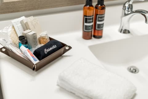 Well-organized bathroom countertop with toiletries and a dark blue towel.