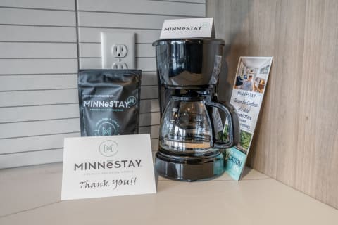 A coffee maker with a package of coffee and a thank you card on a countertop.
