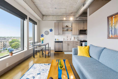 Modern apartment featuring a cozy sofa, dining area, and contemporary kitchen.