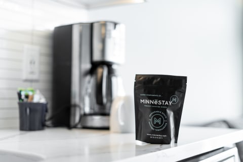 A modern kitchen countertop with MINNESTAY coffee and a coffee maker.