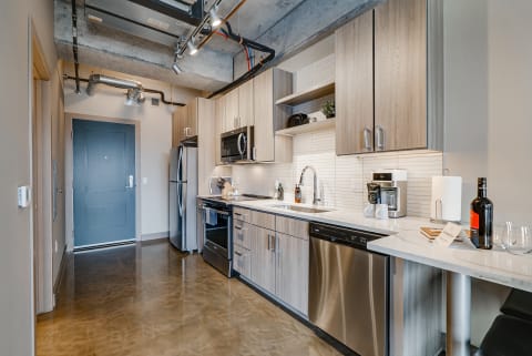 Modern kitchen featuring light wood cabinets and stainless steel appliances.