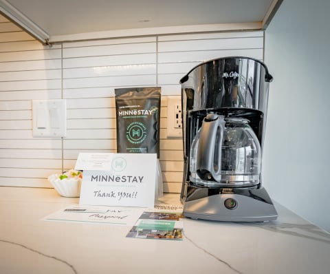 Coffee maker and welcome materials on a kitchen countertop.